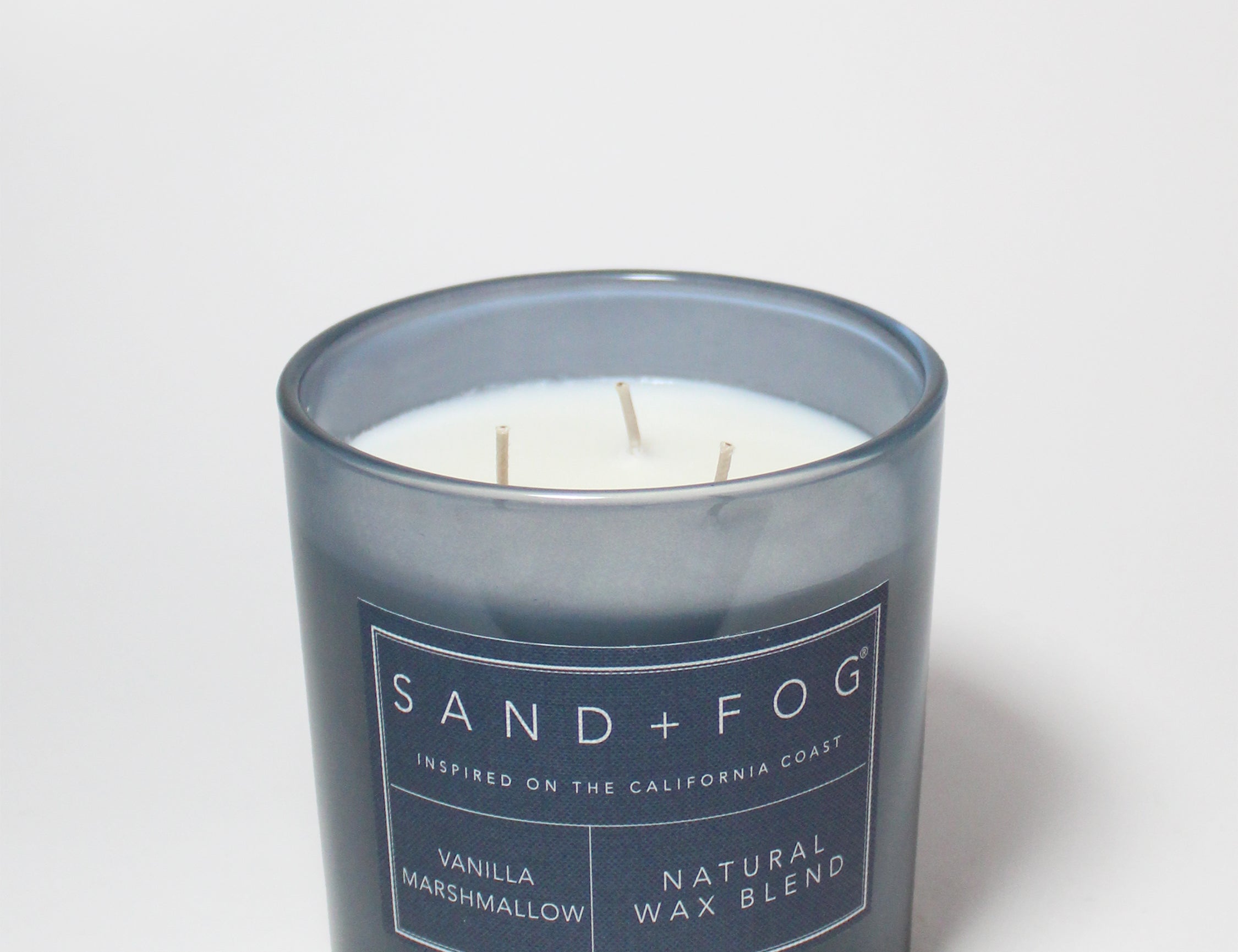 21 oz scented candle in dark blue glass jar with three wicks and label