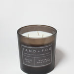 21 oz scented candle in black jar with white label and visible wicks