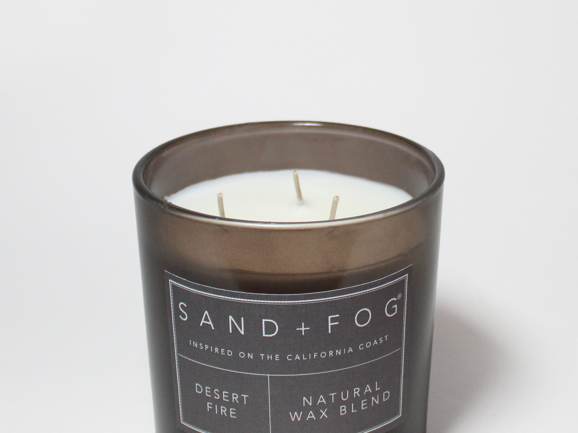 21 oz scented candle in black jar with white label and visible wicks