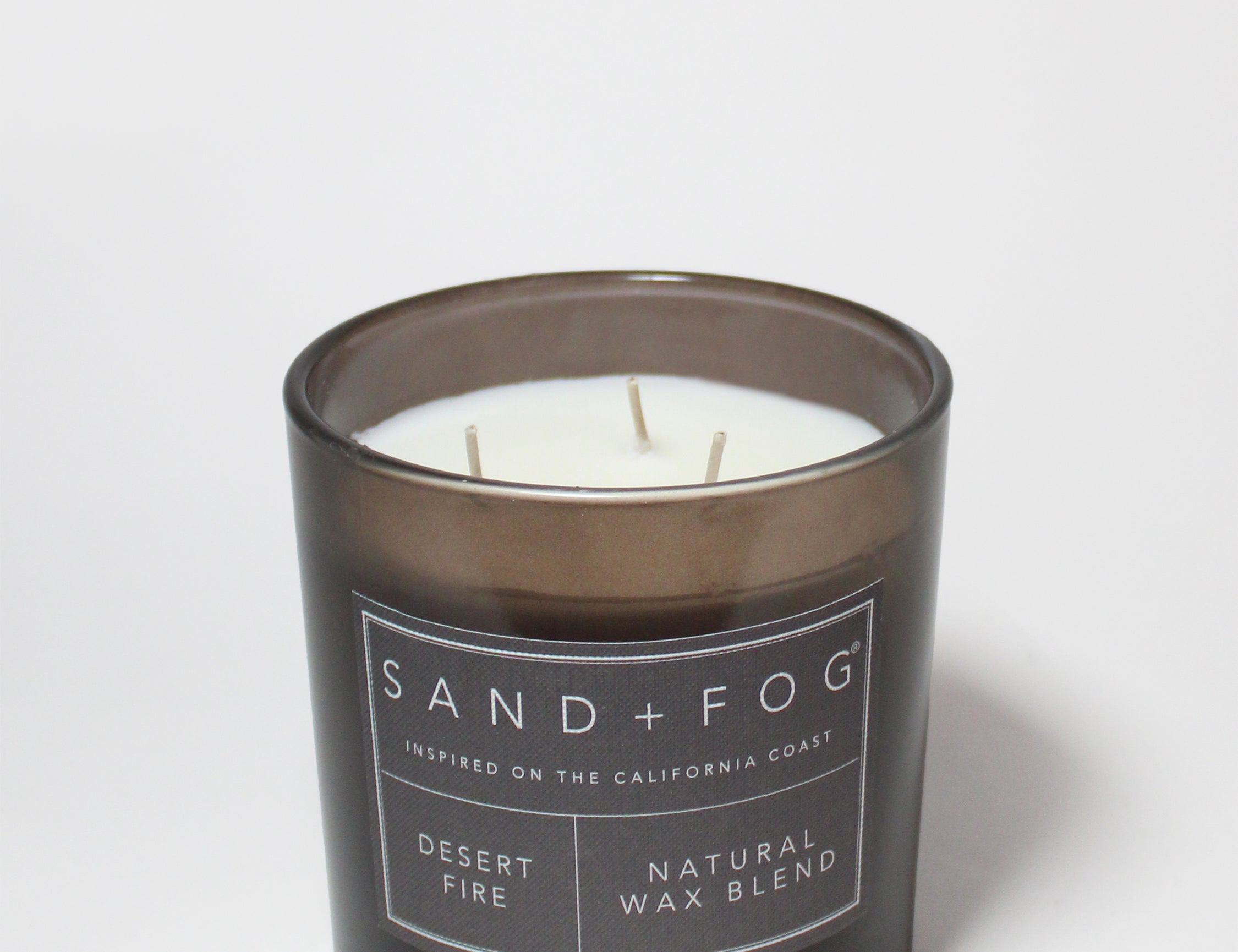 21 oz scented candle in black jar with white label and visible wicks
