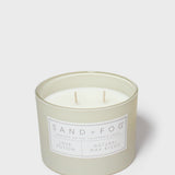Glass jar scented candle with two wicks and Sand+Fog Love Potion label