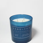Blue scented candle jar with SAND+FOG label and two wicks