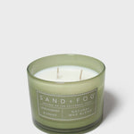 Scented candle in green glass jar with two wicks and Sand+Fog label