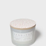 Frosted glass 12 oz scented candle with patterned lid and front label