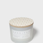 12 oz scented candle with speckled wooden lid and SAND + FOG label