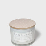 Vanilla orchid scented candle with beige lid and printed label on glass jar