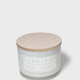 Vanilla orchid scented candle with beige lid and printed label on glass jar
