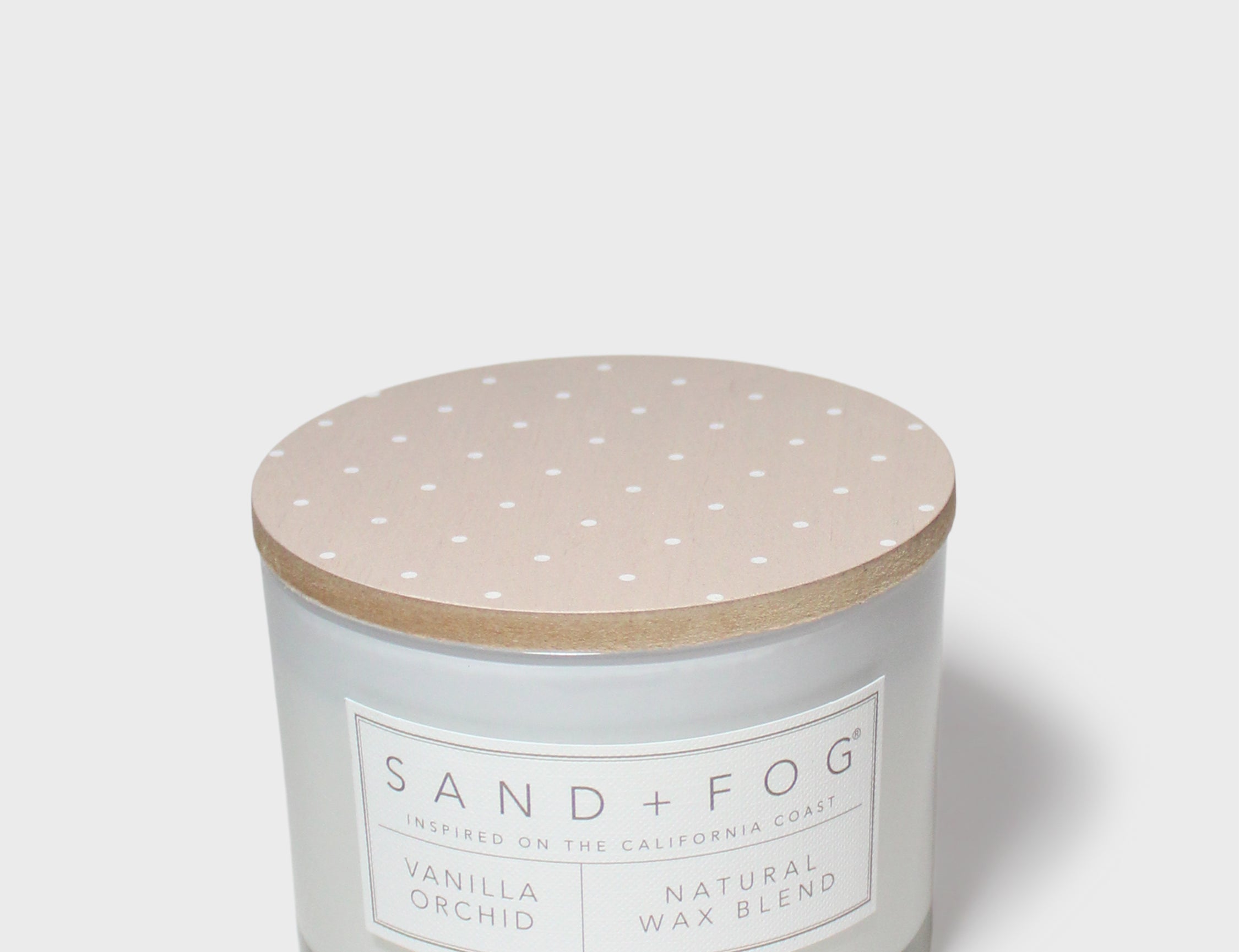 Vanilla orchid scented candle with beige lid and printed label on glass jar