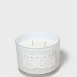 Vanilla orchid scented candle in glass jar with two wicks and centered label