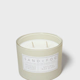 12 oz scented candle in frosted green jar with SAND+FOG label and white wax