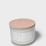 Scented candle jar with speckled terracotta lid and branded front label