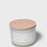 Scented candle jar with speckled terracotta lid and branded front label