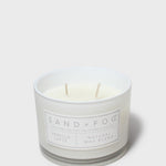 Scented candle in frosted jar with white wax, two wicks, and front label