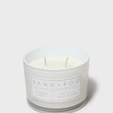 Scented candle in frosted jar with white wax, two wicks, and front label