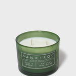 Green glass scented candle with twin wicks and Sand+Fog label