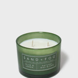 Green glass scented candle with twin wicks and Sand+Fog label