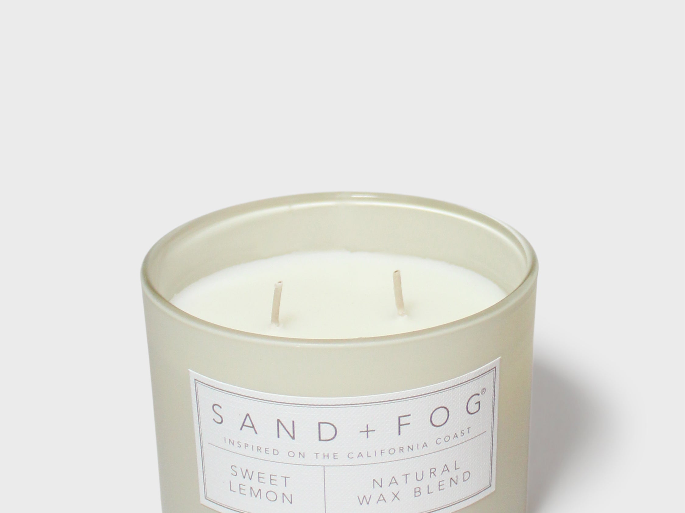 Sand + Fog scented candle in glass jar with Sweet Lemon label