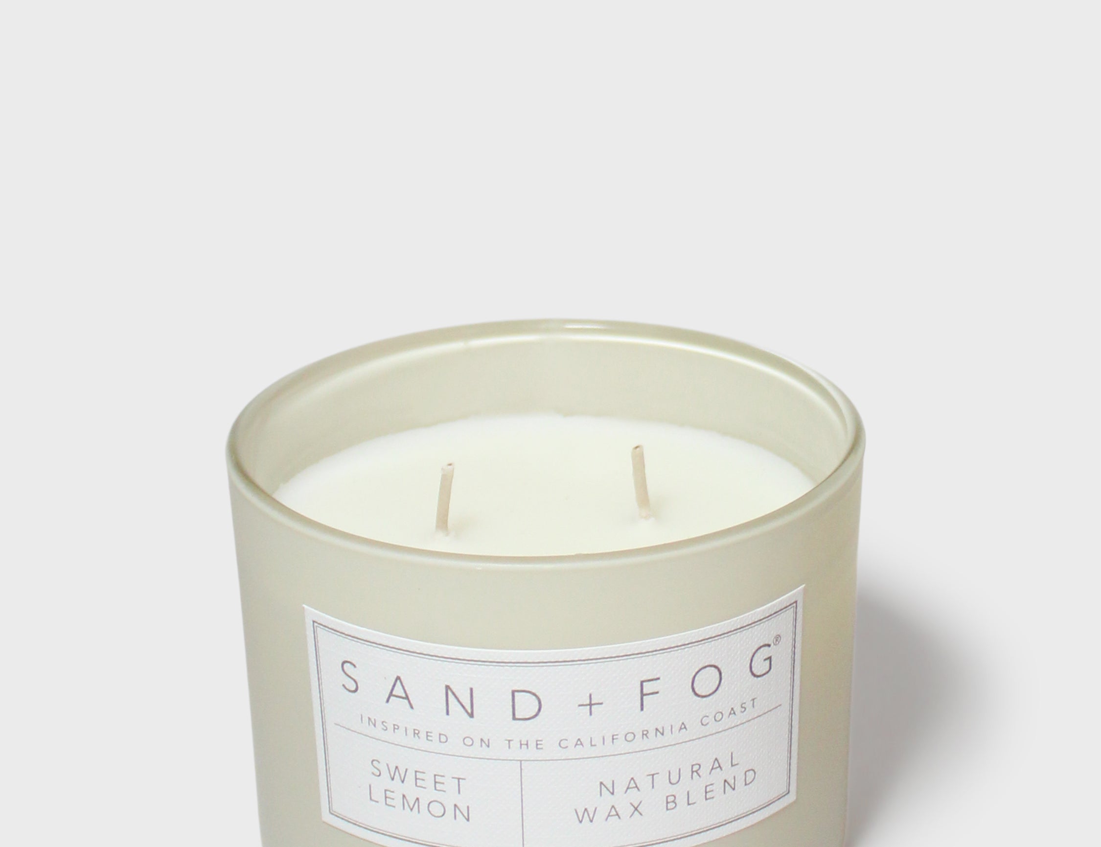 Sand + Fog scented candle in glass jar with Sweet Lemon label
