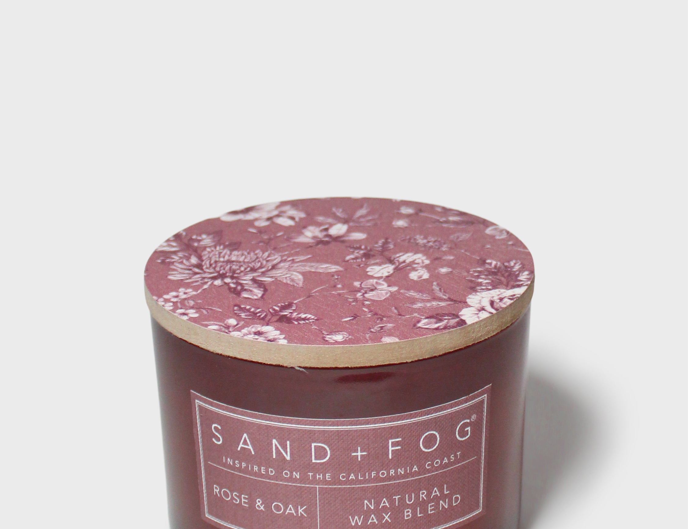 Rose & Oak scented candle with pink floral wax lid and natural blend label on jar