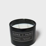 SAND + PAWS teakwood scented candle in black glass jar, unlit