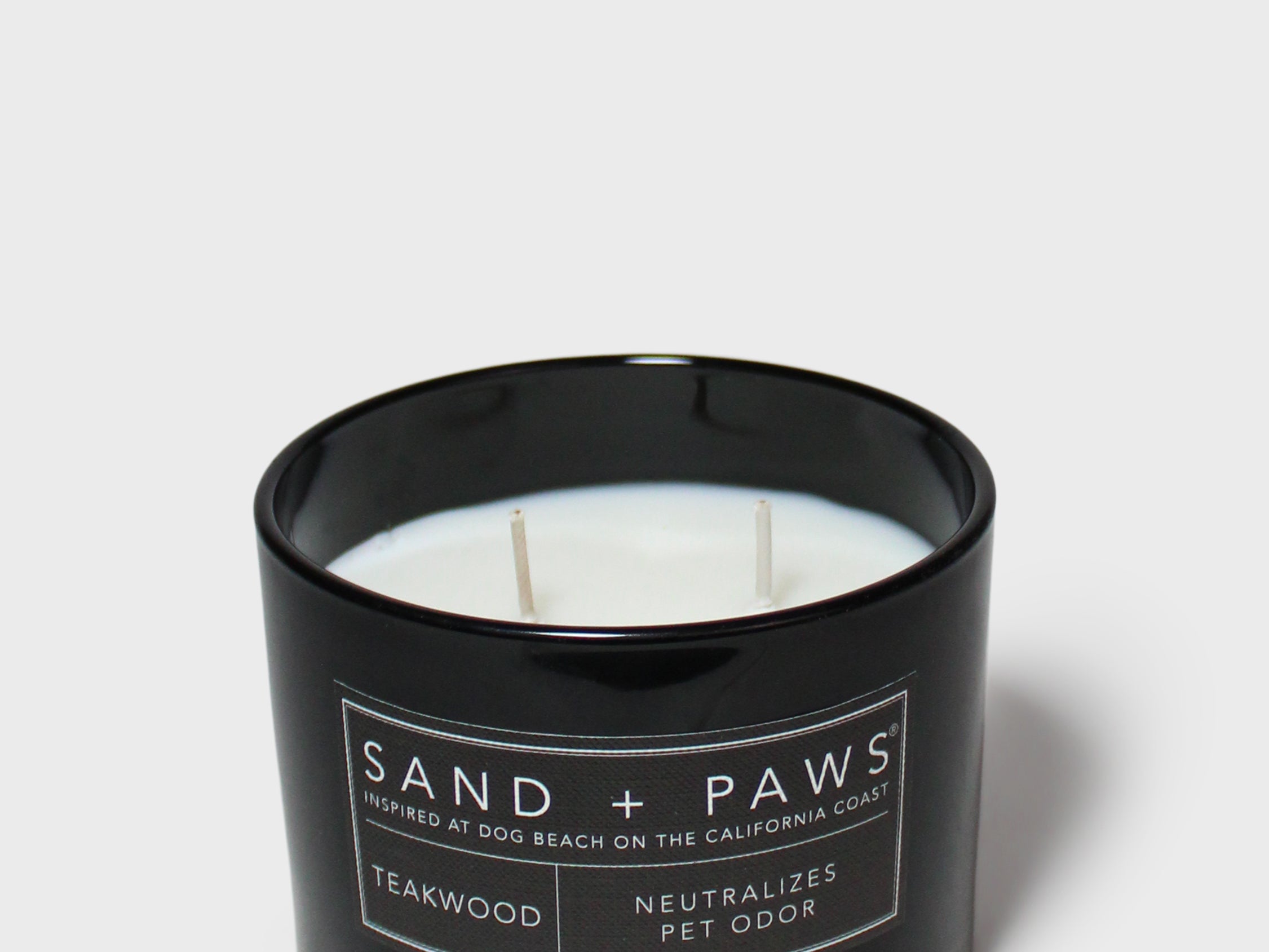 SAND + PAWS teakwood scented candle in black glass jar, unlit