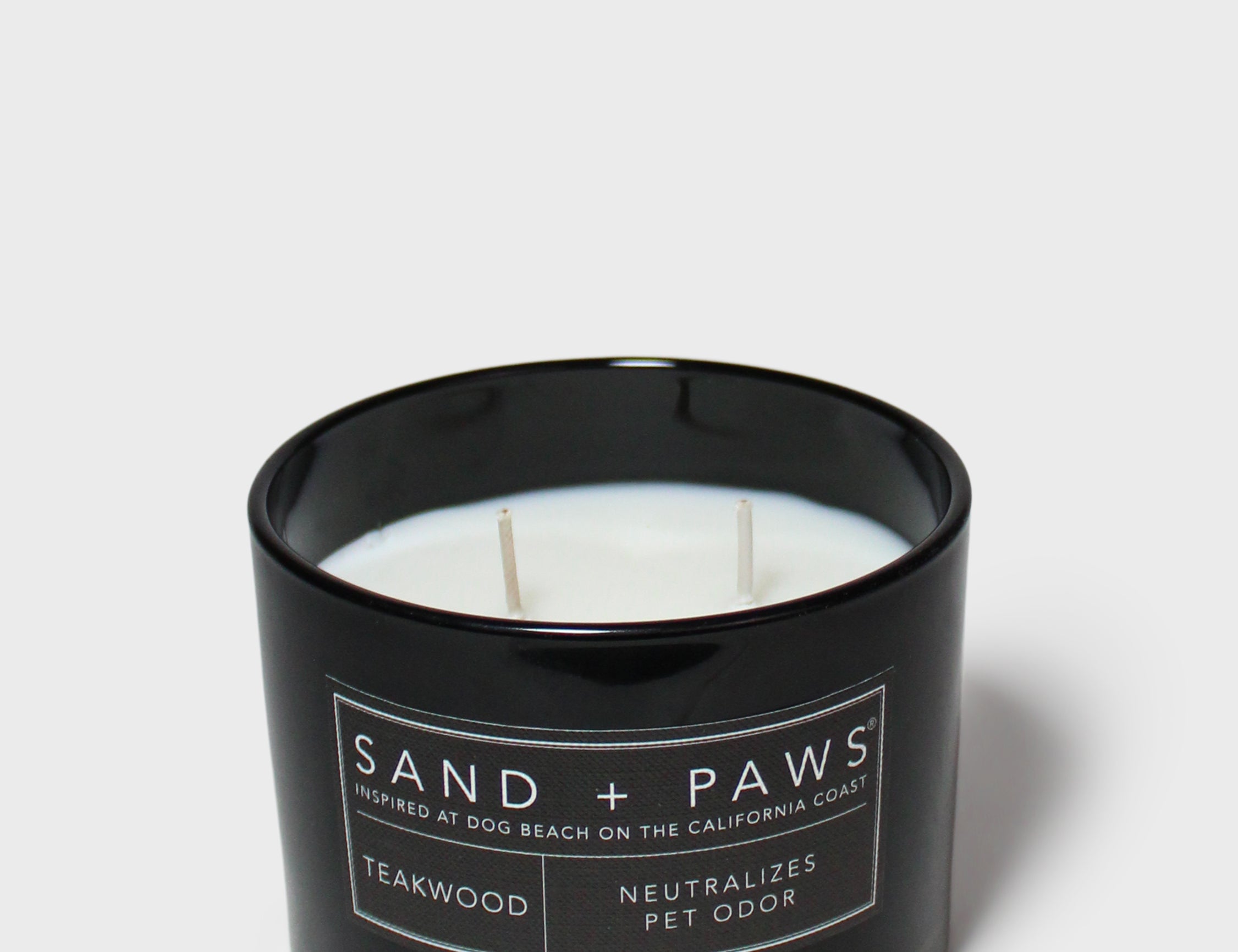 SAND + PAWS teakwood scented candle in black glass jar, unlit