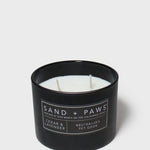 Black candle jar with wick visible and plaid paw label on front