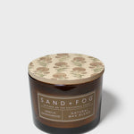 Dark brown scented candle jar with beige patterned lid and Vanilla Sandalwood label