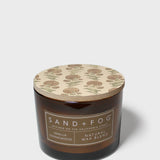 Dark brown scented candle jar with beige patterned lid and Vanilla Sandalwood label