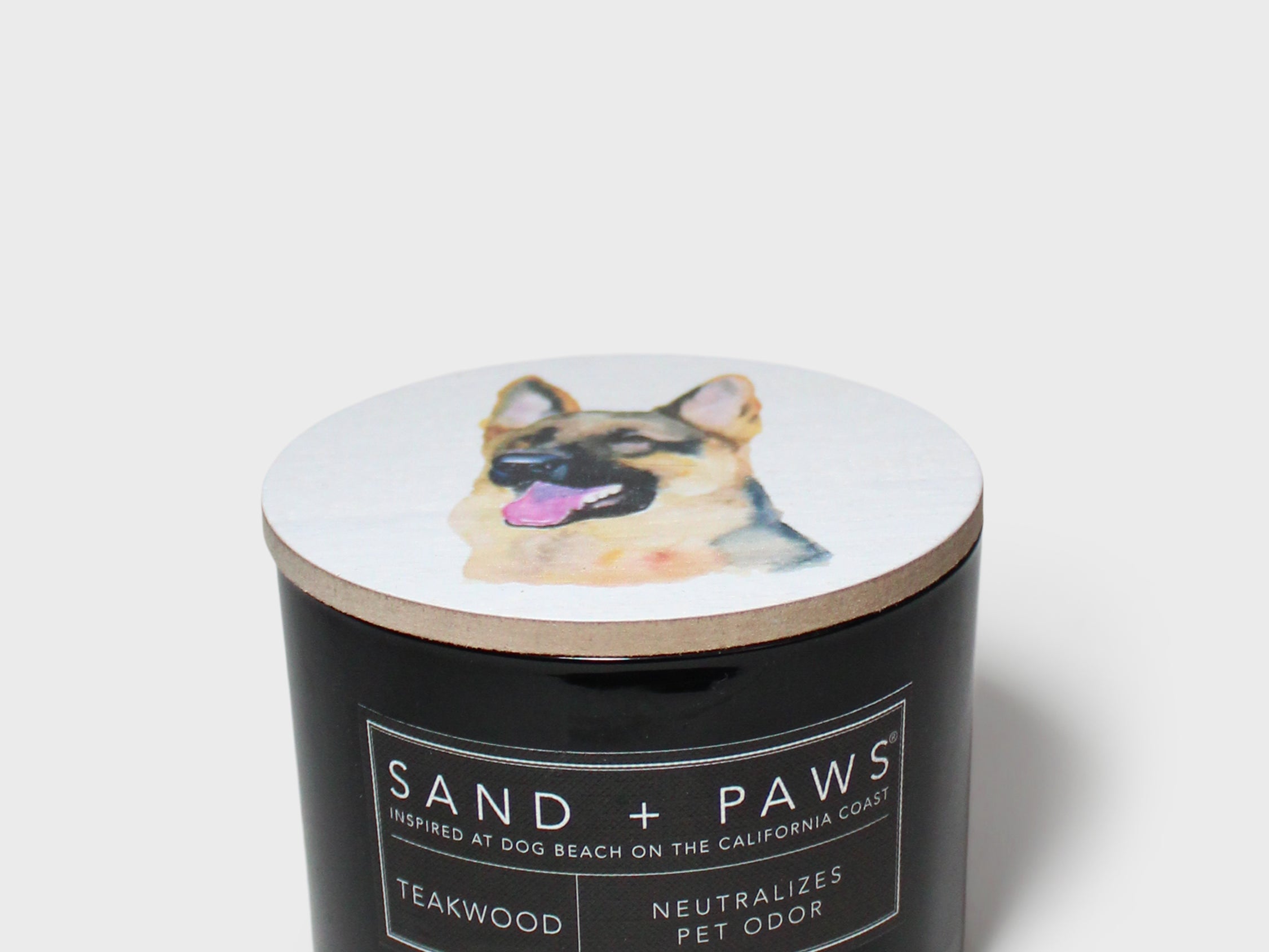 12 oz scented candle with black jar, dog lid graphic, and label text