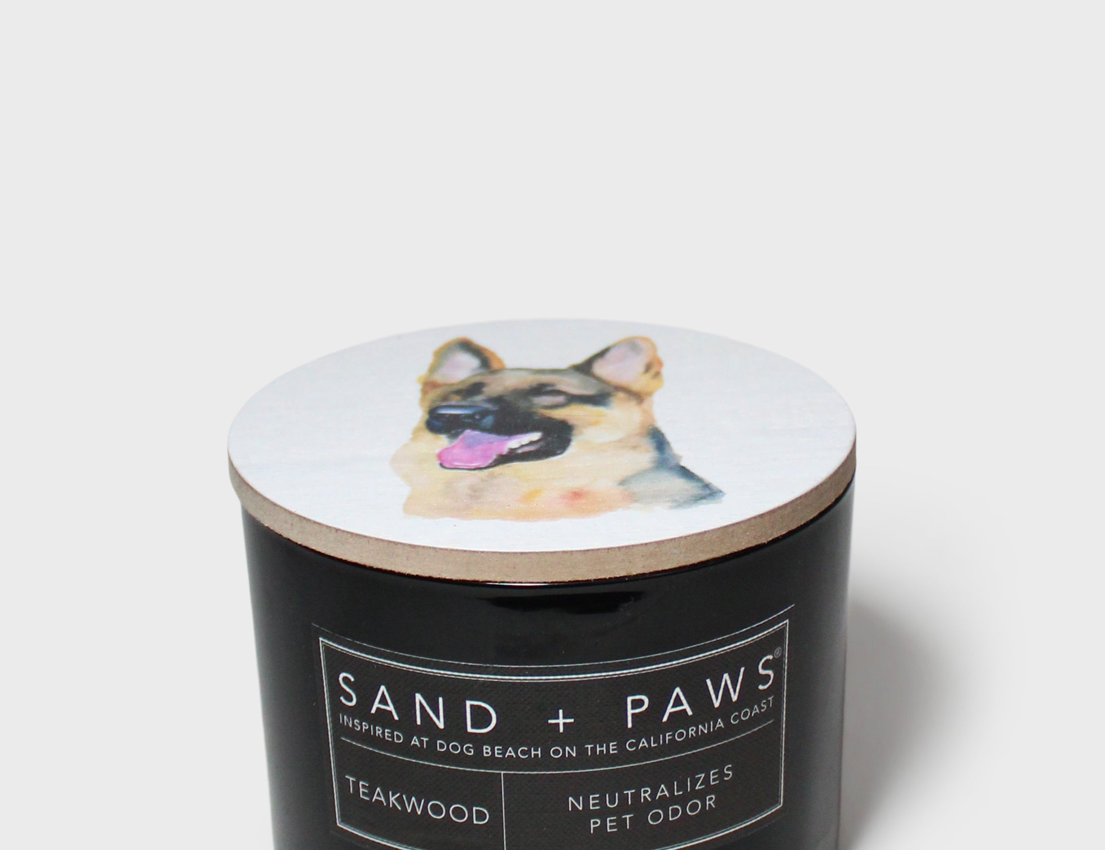 12 oz scented candle with black jar, dog lid graphic, and label text
