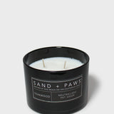 Scented candle in black jar with wicks and Teakwood label on front