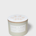 Mint green scented candle with paw print lid and “SAND + PAWS” label