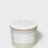 Mint green scented candle with paw print lid and “SAND + PAWS” label