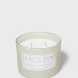 Mint green scented candle in jar with “SAND + PAWS” label and two wicks