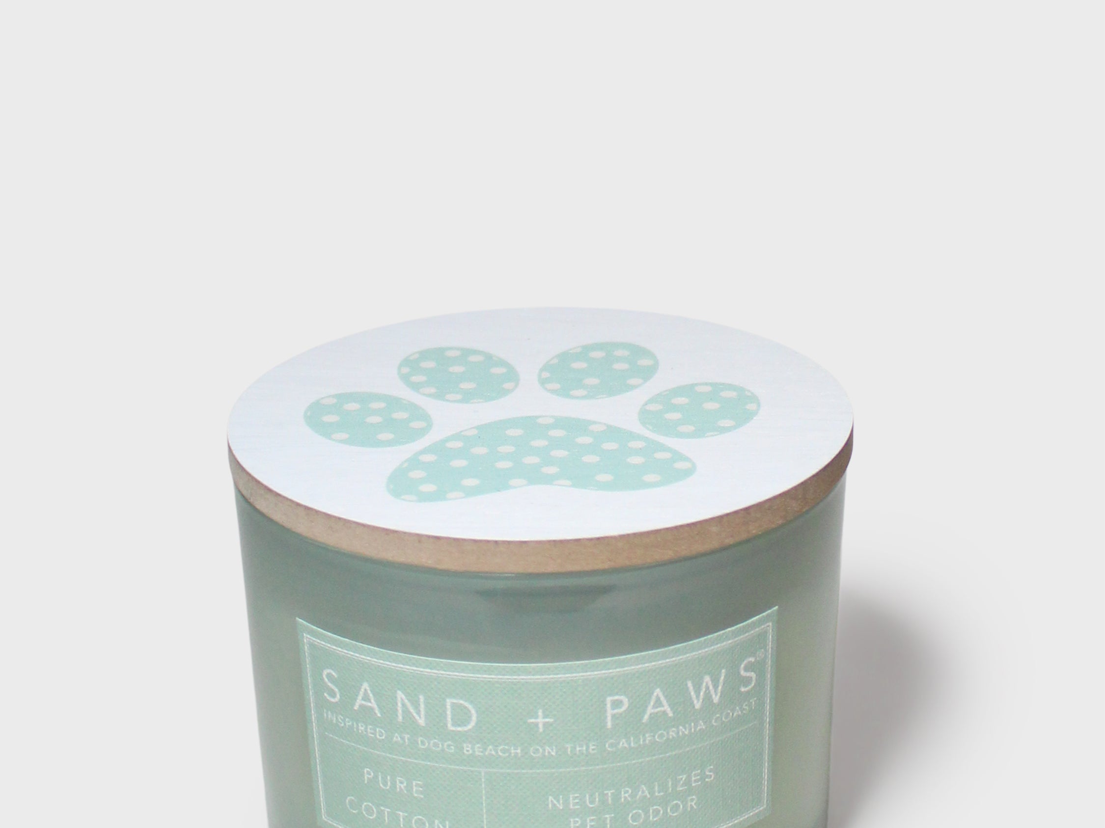 Scented candle jar lid with pale paw-print design on light white top