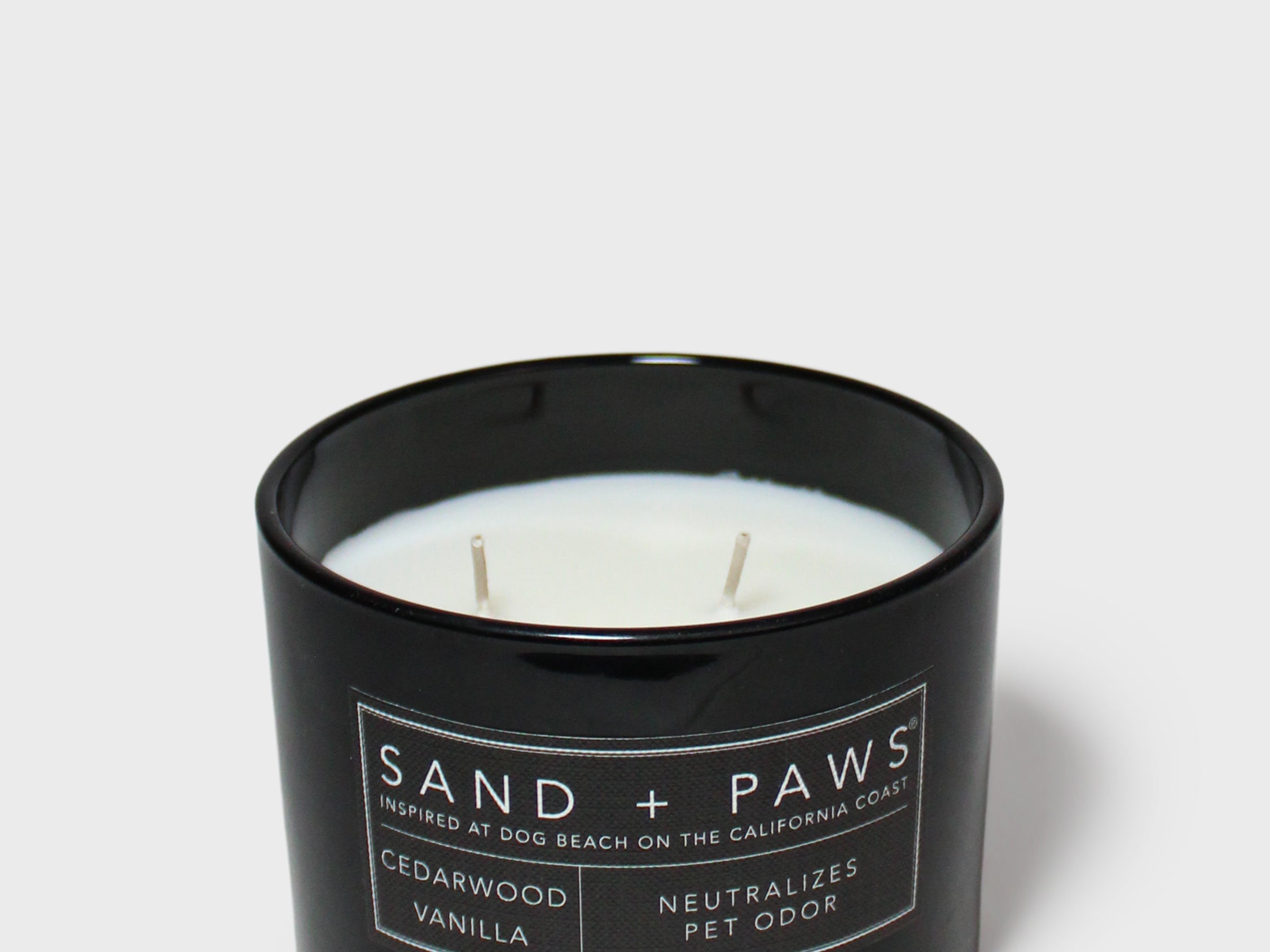 Black jar scented candle with cream wax and Sand + Paws label