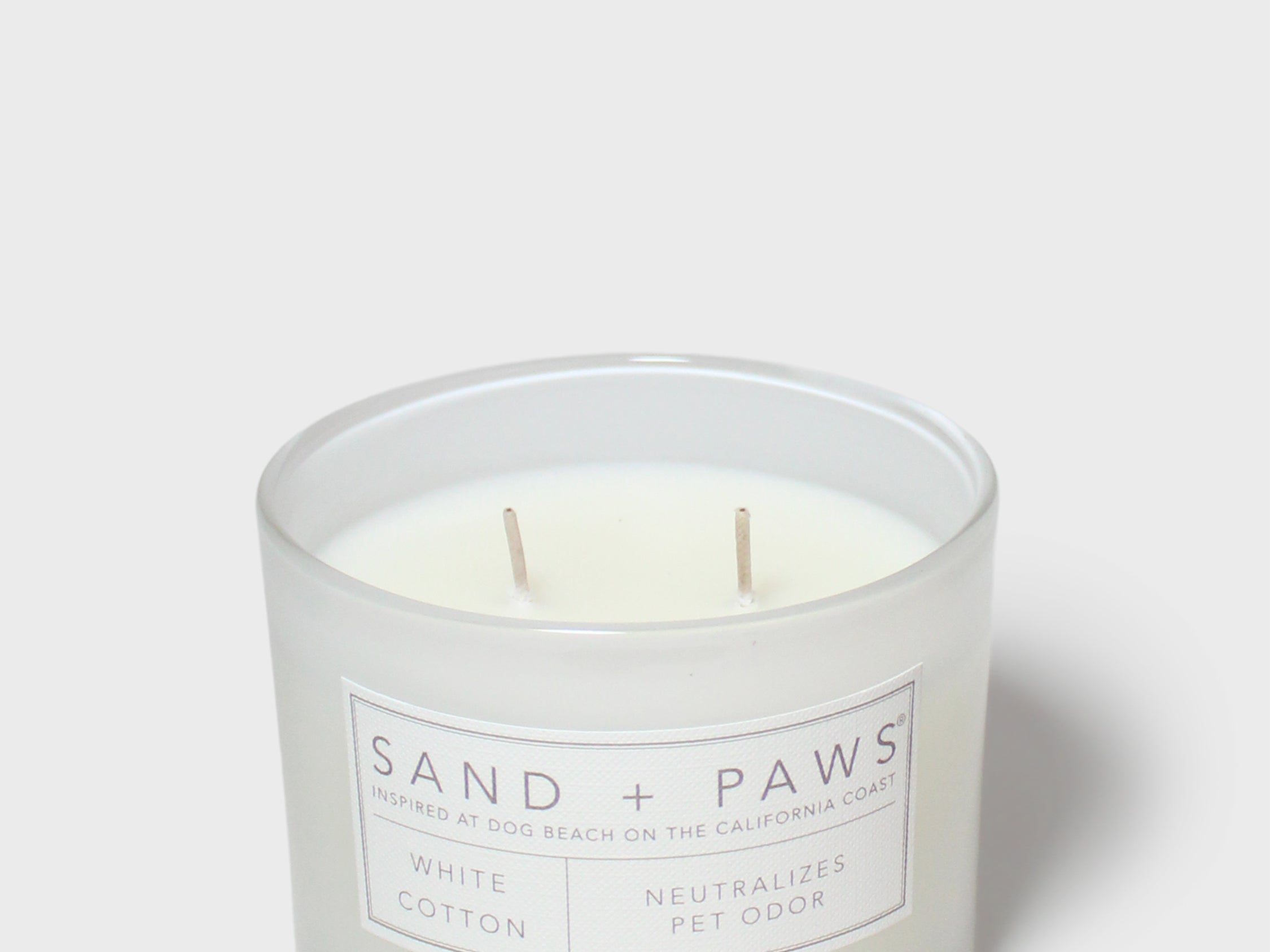 Sand + Paws white cotton scented candle in frosted glass jar with front label