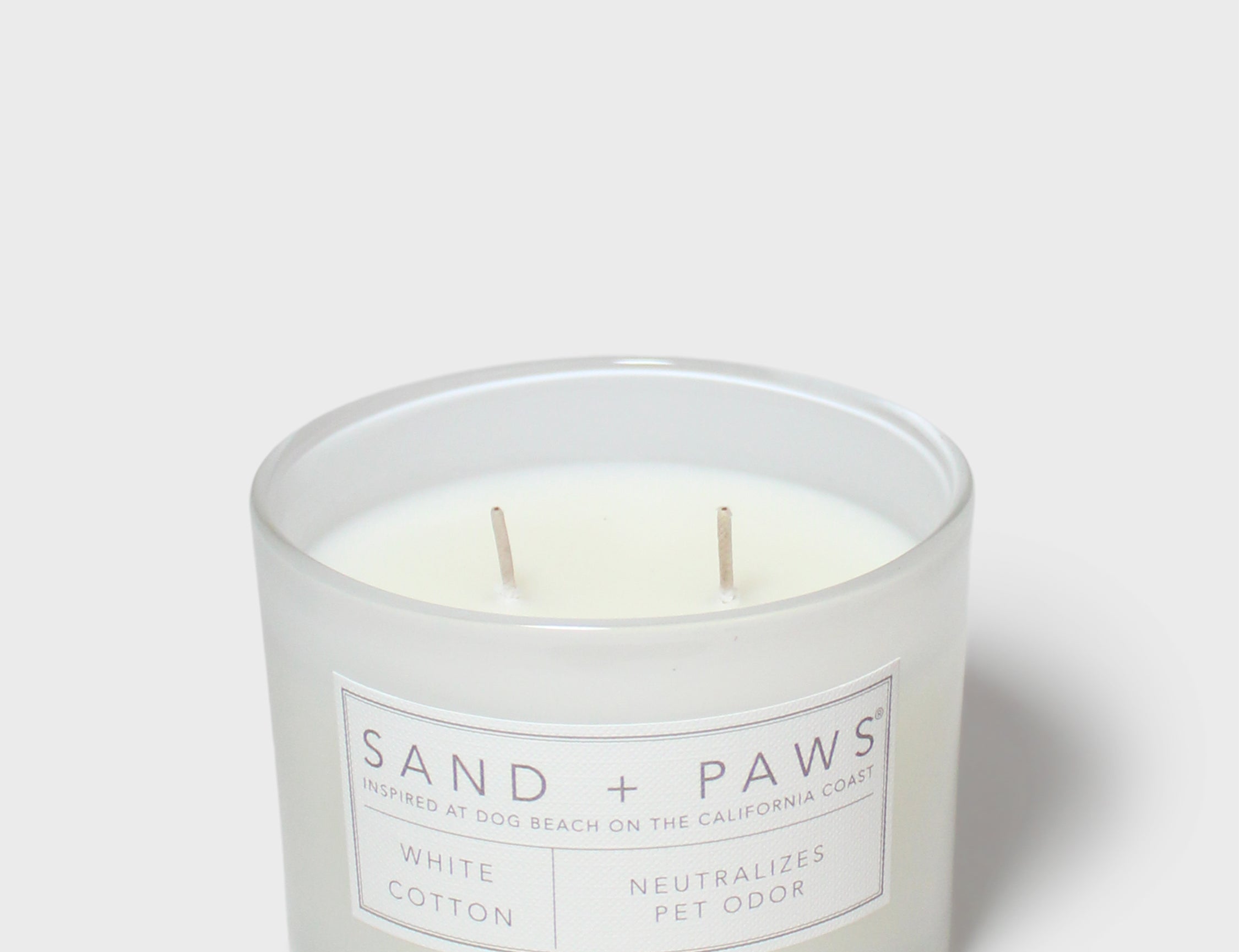 Sand + Paws white cotton scented candle in frosted glass jar with front label