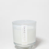 Cashmere & Cardamom scented candle in a clear glass jar with a white wax fill and label.