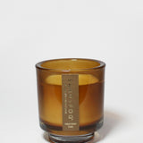Western Oak 8 oz scented candle in an amber glass jar, shown open with wax visible.