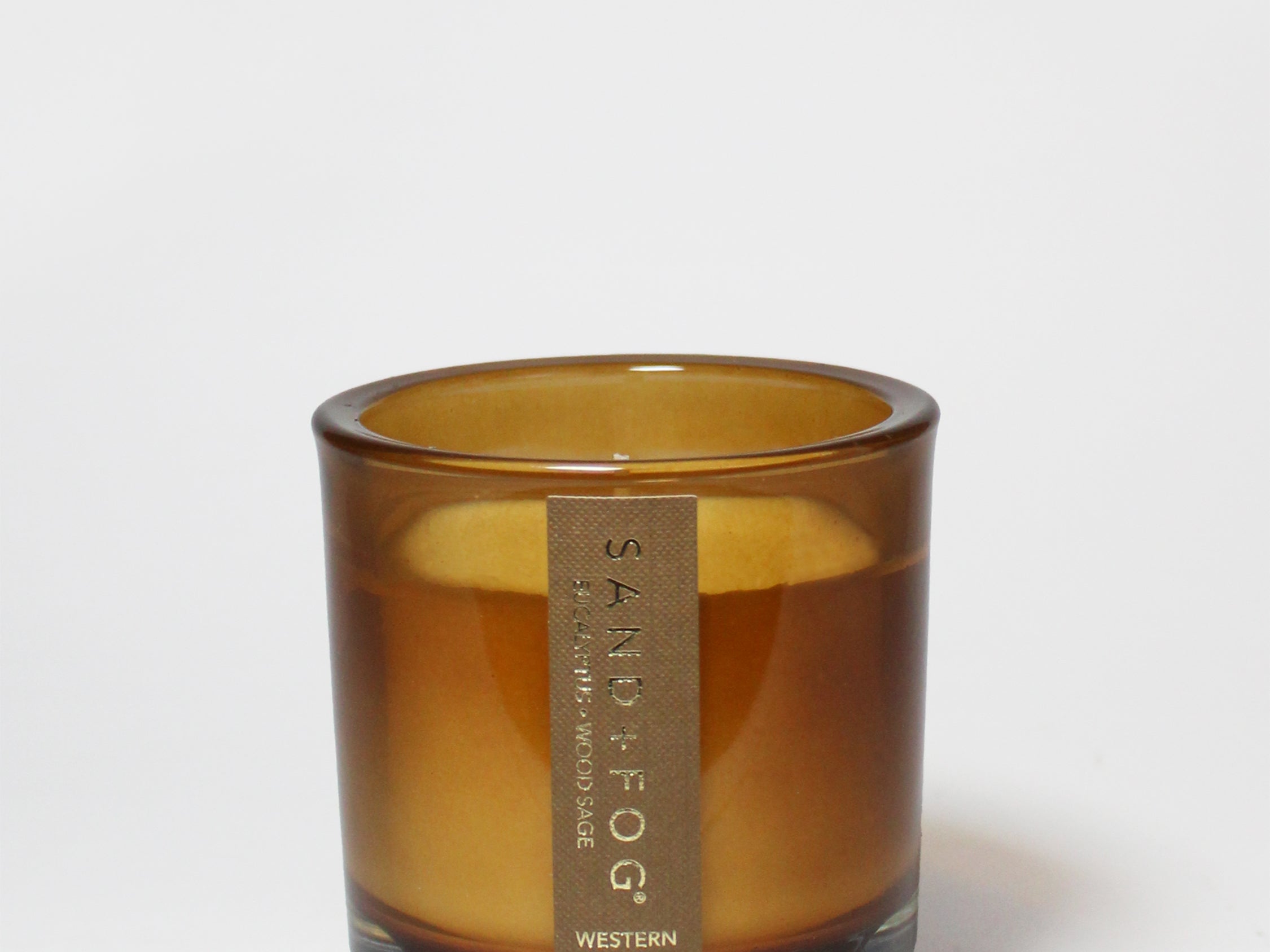 Western Oak 8 oz scented candle in an amber glass jar, shown open with wax visible.