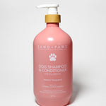 Pink pet shampoo & conditioner bottle with white pump, Sand + Paws label, mango tangerine