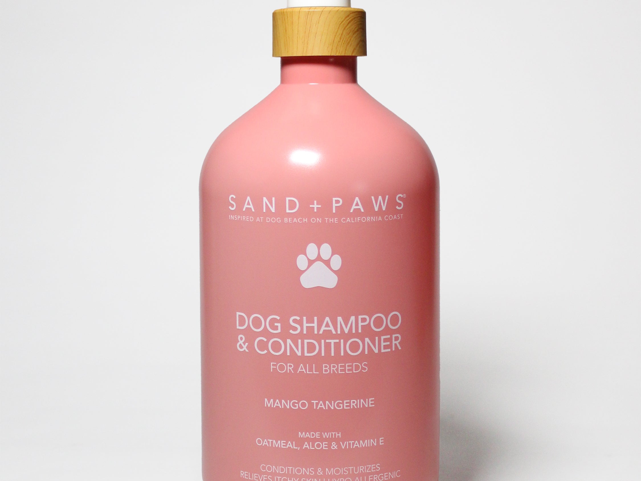 Pink pet shampoo & conditioner bottle with white pump, Sand + Paws label, mango tangerine