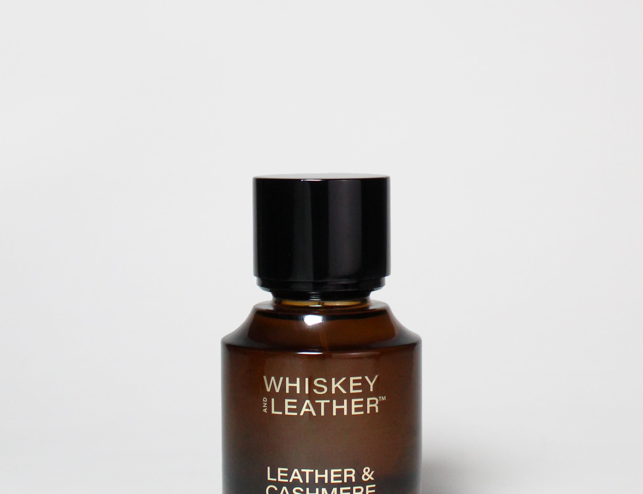 Leather & Cashmere cologne bottle with dark brown glass and black cap