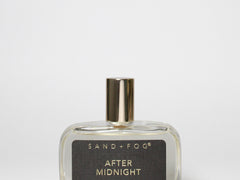 Glass eau de toilette bottle with gold cap, dark label reading After Midnight.