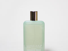 Light green room spray bottle with gold cap and minimal front label