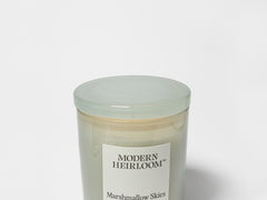 Scented candle in light green glass jar with Modern Heirloom label, unlit
