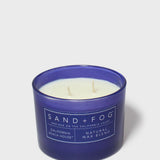 Blue scented candle in glass jar, SAND+FOG label and natural wax blend