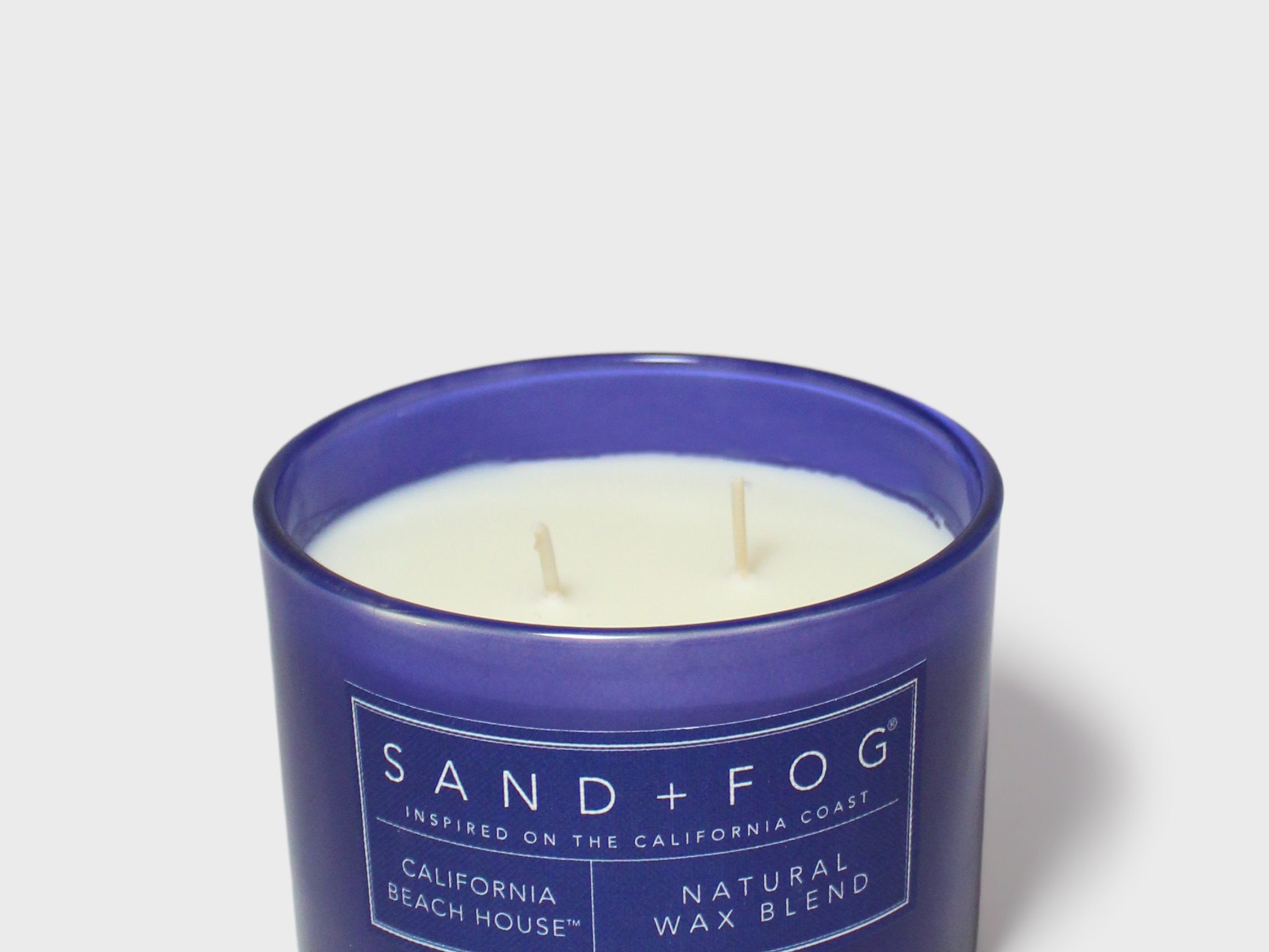 Blue scented candle in glass jar, SAND+FOG label and natural wax blend